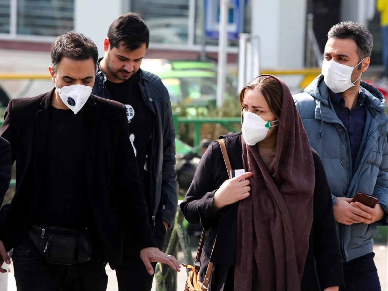 Iranians, some wearing protective masks, wait to cross a street in the capital Tehran on February 22, 2020. (AFP)
