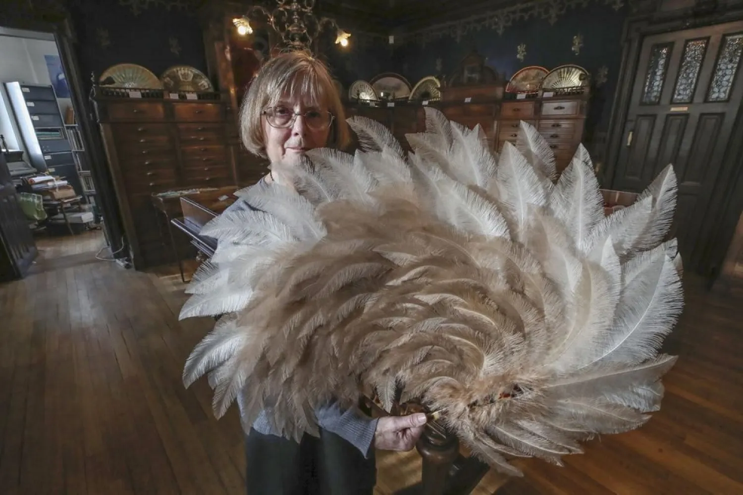 Anne Hoguet, 74, fan-maker and director of the hand fan-making museum poses with a feather fan at the museum in Paris, Wednesday, Jan. 20, 2021. (AP)