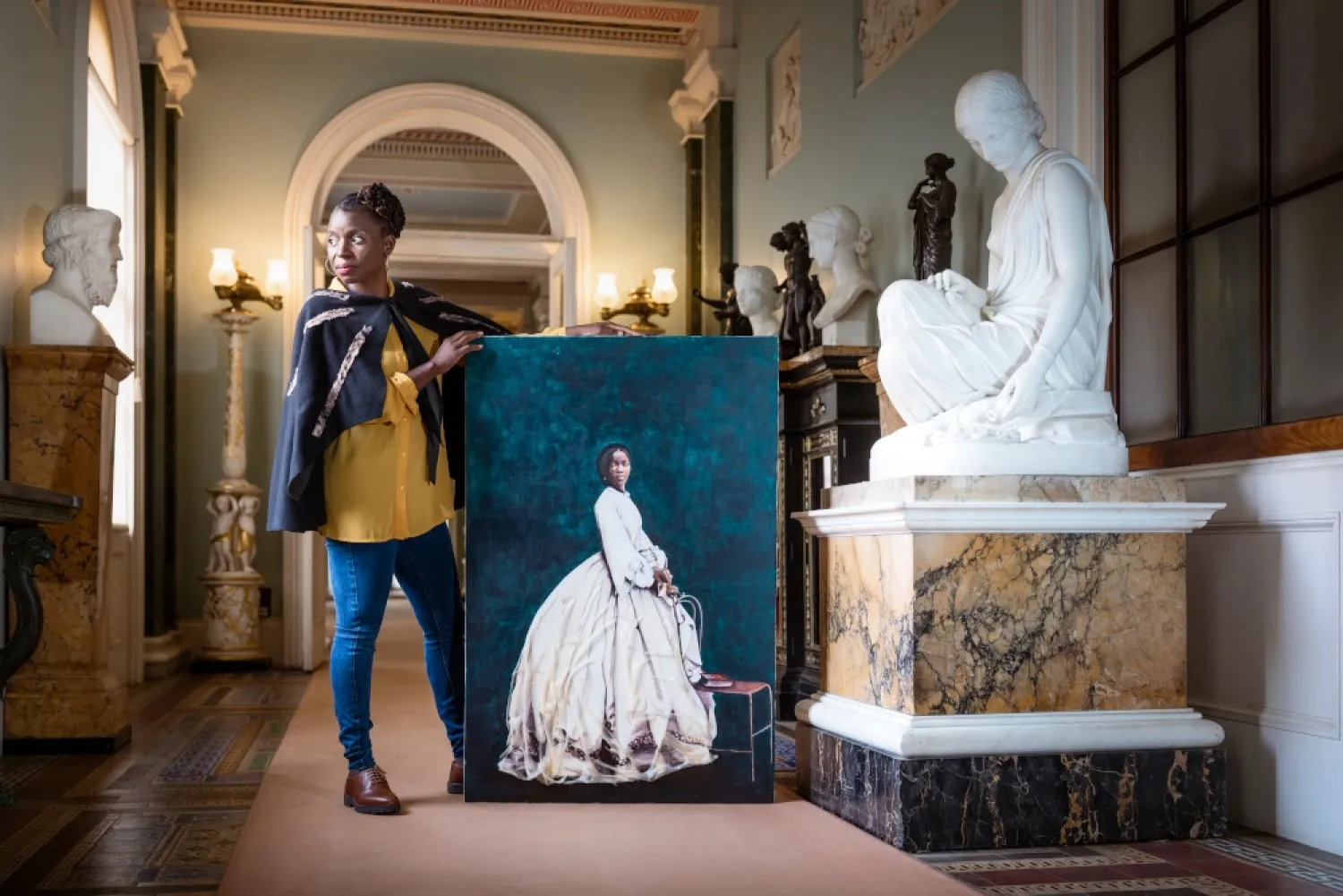 British-Zambian artist Hannah Uzor poses next to her portrait of Sarah Forbes Bonetta at Osbourne House in the Isle of Wight, Britain. (English Heritage via Reuters)