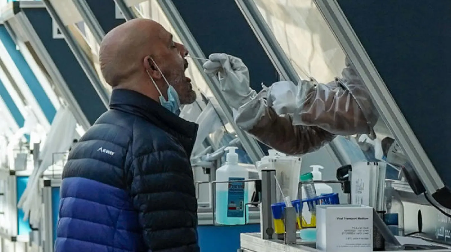 فحص مسافر بمطار «بن غوريون» أمس قبل بدء حظر شبه كامل على السفر (د.ب.أ)