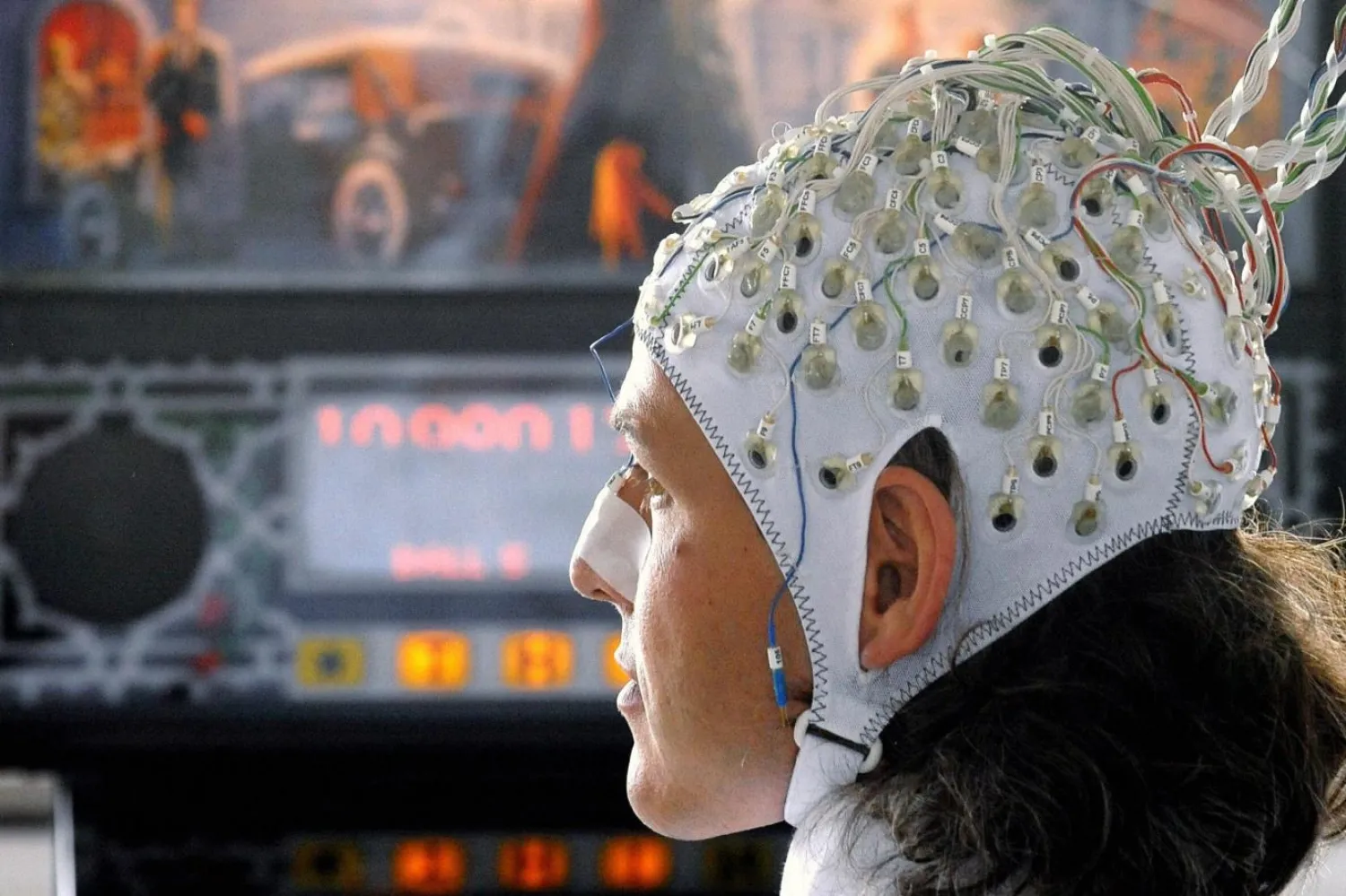 4 Haziran 2009'da Berlin'de beyin-bilgisayar arayüzü teknolojisinin erken bir tanıtımında bir araştırmacı kafasına takılan elektrotlar aracılığıyla pinball makinesi kullanıyor (AFP)