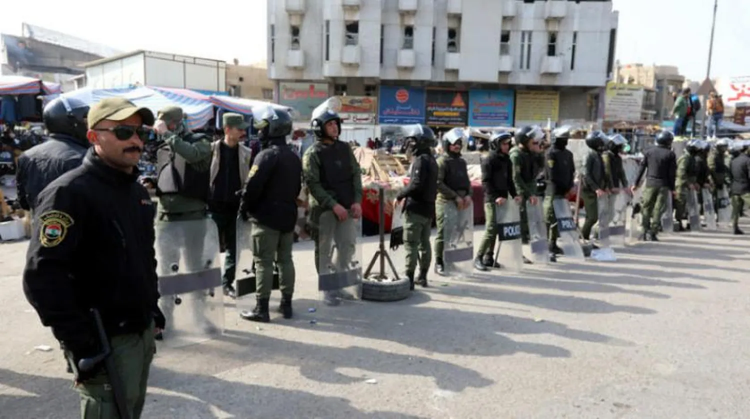 Geçen perşembe günü iki saldırıya tanık olan Bağdat’ın Tayeran Meydanı’ndaki eylemcileri koruyan polis gücü (AFP)