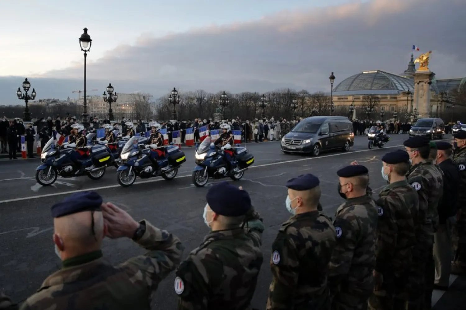 French soldiers stand in an honor guard on Thursday Jan.7, 2021 as the hearse convoy of late French forces soldiers rides on the Alexandre III bridge in central Paris. A ceremony was held to pay homage to two soldiers killed in Mali by an improvised explosive device that hit their armored vehicle. (AP Photo/Christophe Ena)

