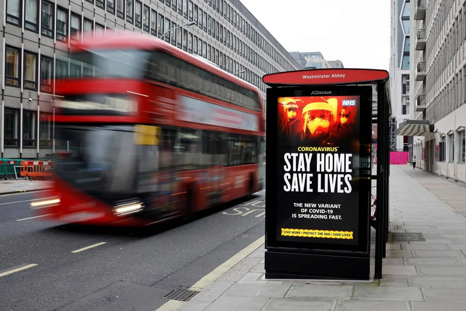 A digital display at a bus station warns pedestrians of the new strain of coronavirus in central London. (AFP)