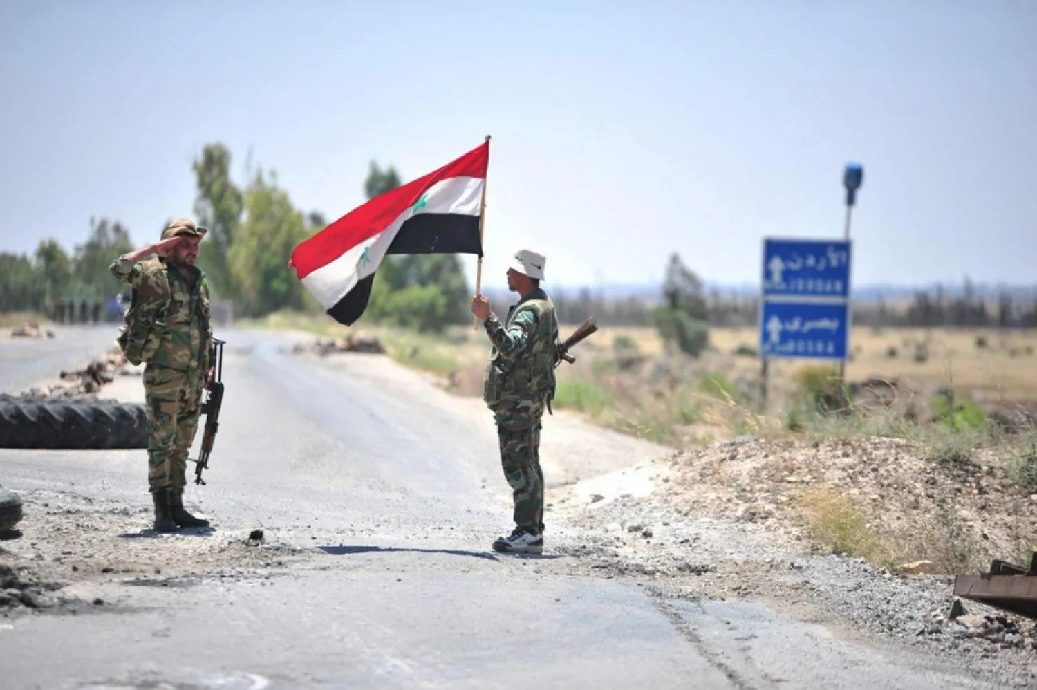 Member of forces loyal to Syria's president Assad salutes a national flag in Daraa province. (Reuters file photo)