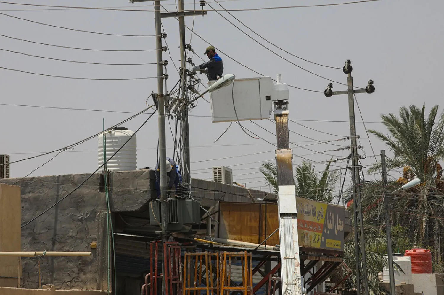 Ministry of Electricity workers maintain the electricity transmission network in Basra, Iraq, Thursday, July. 30, 2020. (AP)