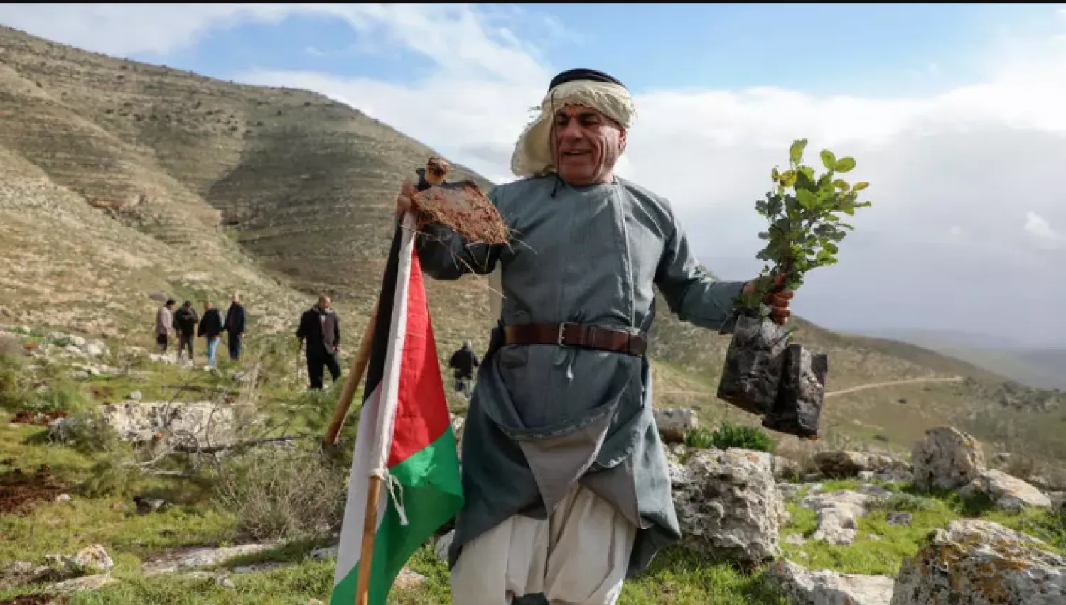 Carrying spades and pickaxes, dozens of Palestinian activists and staff from the Palestinian agriculture ministry worked to plant trees in a valley near Khirbeit Einoun, in Tubas governorate - AFP