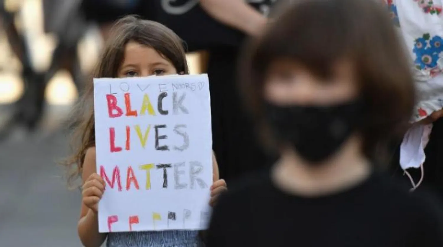 طفلة تشارك في الاحتجاجات بنيويورك حاملة شعار «حياة السود مهمة» (أ.ف.ب)