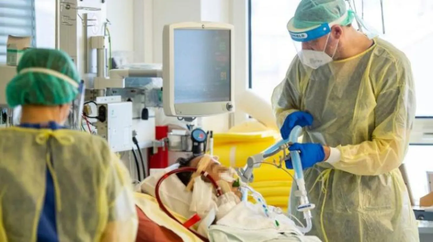 طبيب يفحص مريضاً مصاباً بفيروس كورونا داخل قسم العناية المشددة بمستشفى في ألمانيا (أ.ف.ب)