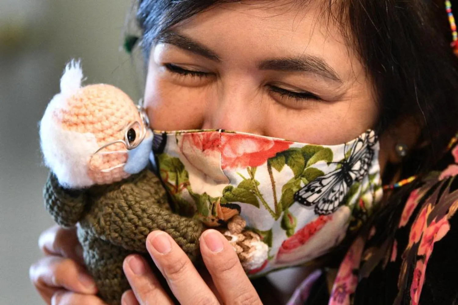 Tobey King, of Corpus Christi, Texas, embraces the crochet Bernie Sanders doll that she made and sold on eBay on Tuesday, Jan. 26, 2021. AP