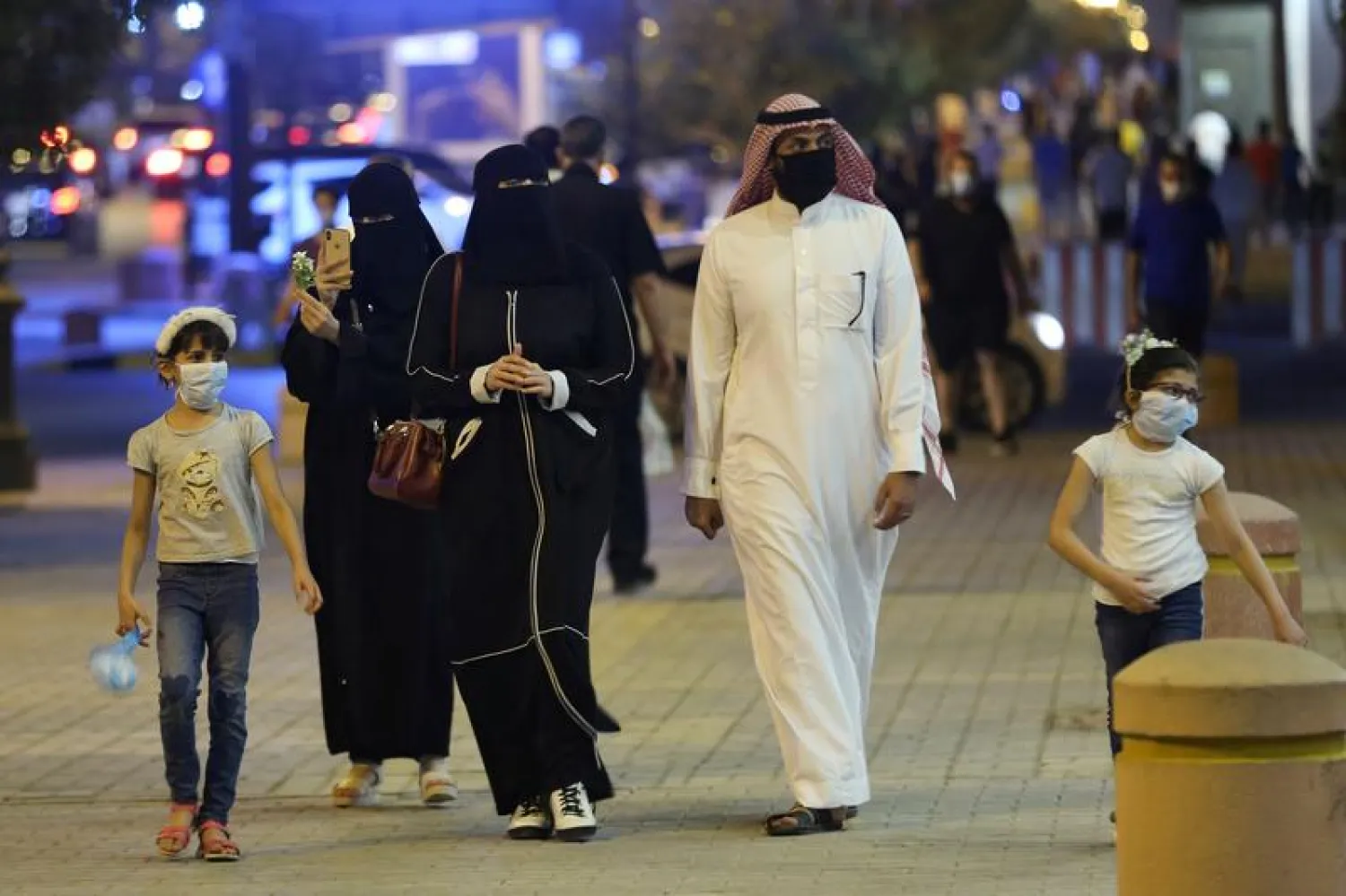 A Saudi family wearing protective face masks walk on Tahlia Street as nightlife kicks off, after the government loosened lockdown restrictions following the outbreak of the coronavirus disease (COVID-19), in Riyadh, Saudi Arabia June 21, 2020. REUTERS/Ahmed Yosri
