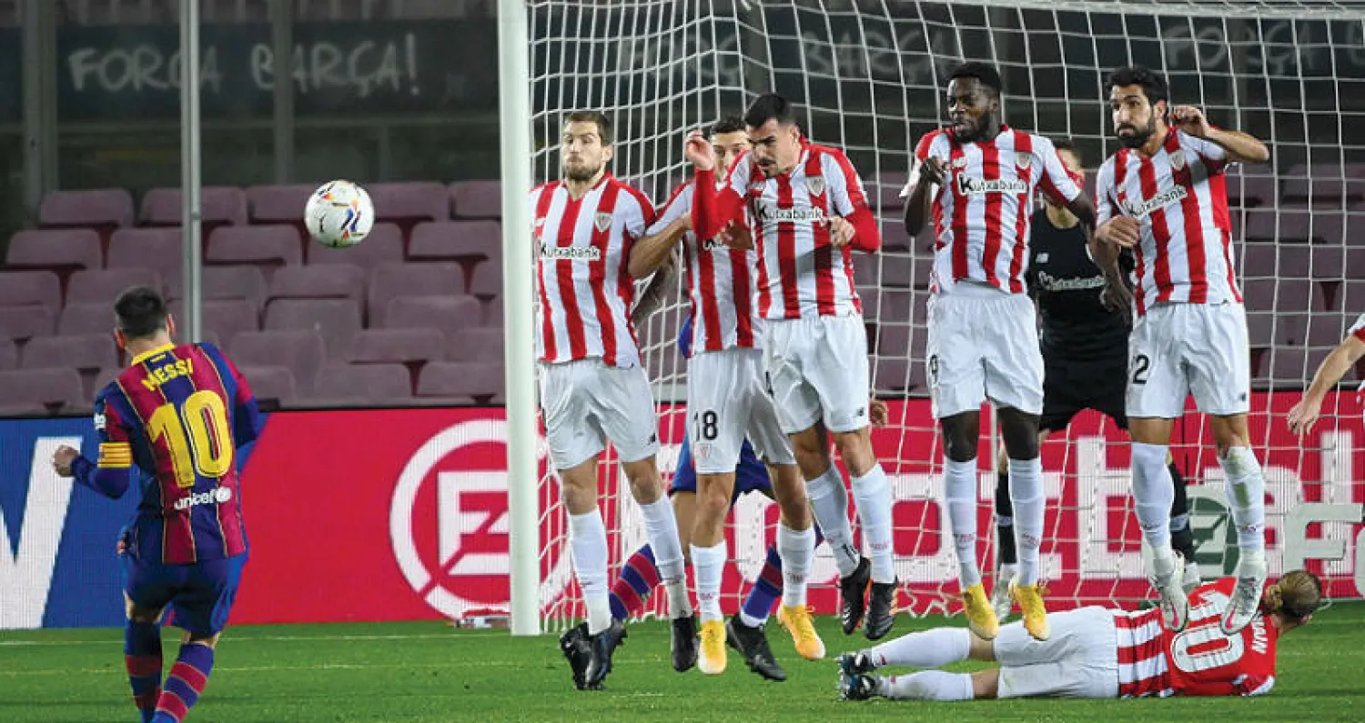 ميسي يسدد بمهارة الركلة الحرة مسجلاً هدف برشلونة الأول في مرمى بلباو (أ.ف.ب)