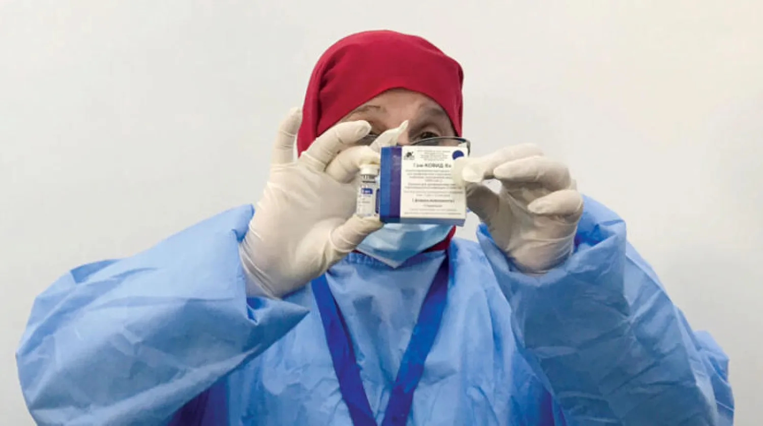 موظفة بقطاع الصحة تحمل جرعة من لقاح {سبوتنيك} الروسي لدى بدء حملة التطعيم ضد {كورونا} في العاصمة الجزائرية يوم الأحد (رويترز)