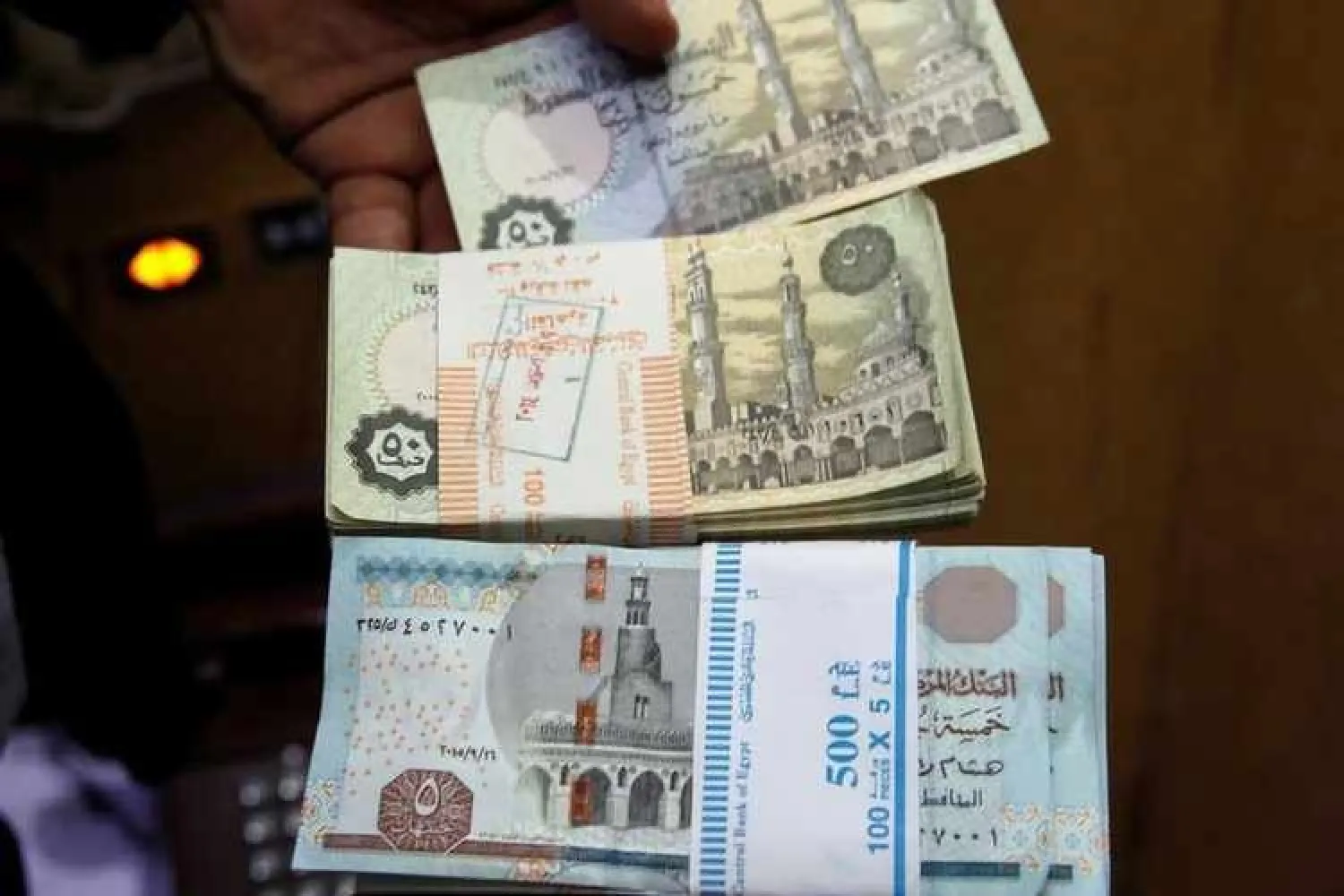 Image used for illustrative purpose. A bank employee counts stacks of Egyptian 5 pound and 50 piastre notes as he works at Bank Misr in downtown Cairo, Egypt, on June 8, 2016. Reuters/Amr Abdallah Dalsh 