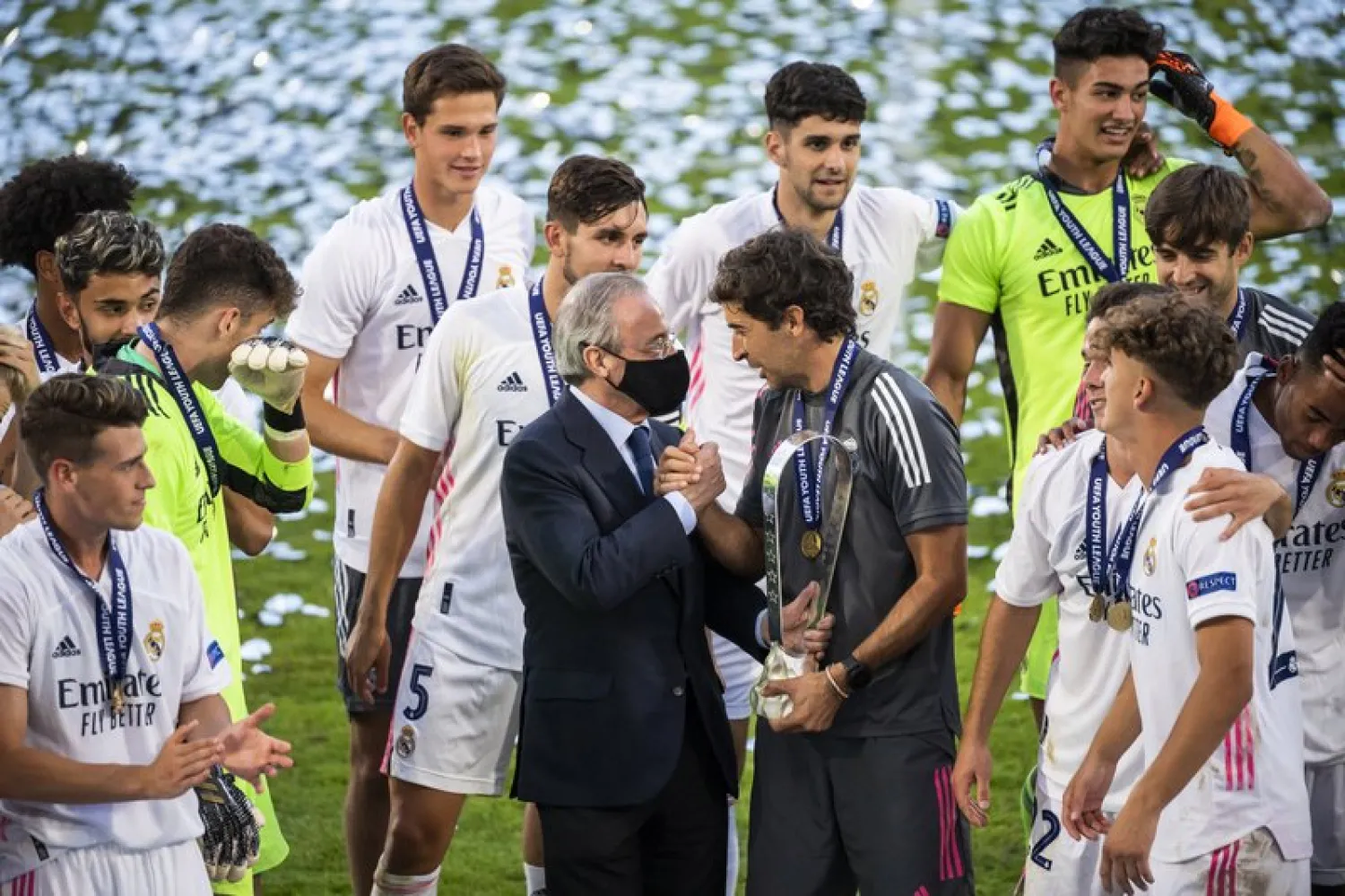 Real Madrid's team players with Real Madrid president Florentino Perez, center left and Real Madrid's head coach Raul Gonzalez Blanco,celebrate with the trophy after winning the UEFA Youth League final soccer match between SL Benfica from Portugal and Real Madrid CF from Spain at the Colovray Sports Center stadium in Nyon, Switzerland, Tuesday, Aug. 25, 2020. (Jean-Christophe Bott/Keystone via AP)
