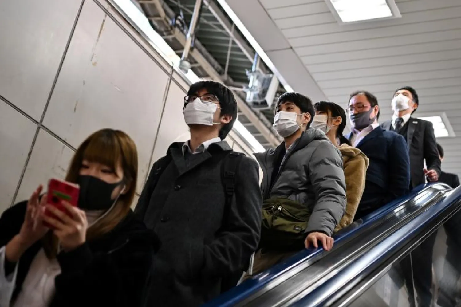يابانيون يرتدون أقنعة الوقاية داخل محطة قطار في طوكيو (أ.ف.ب)