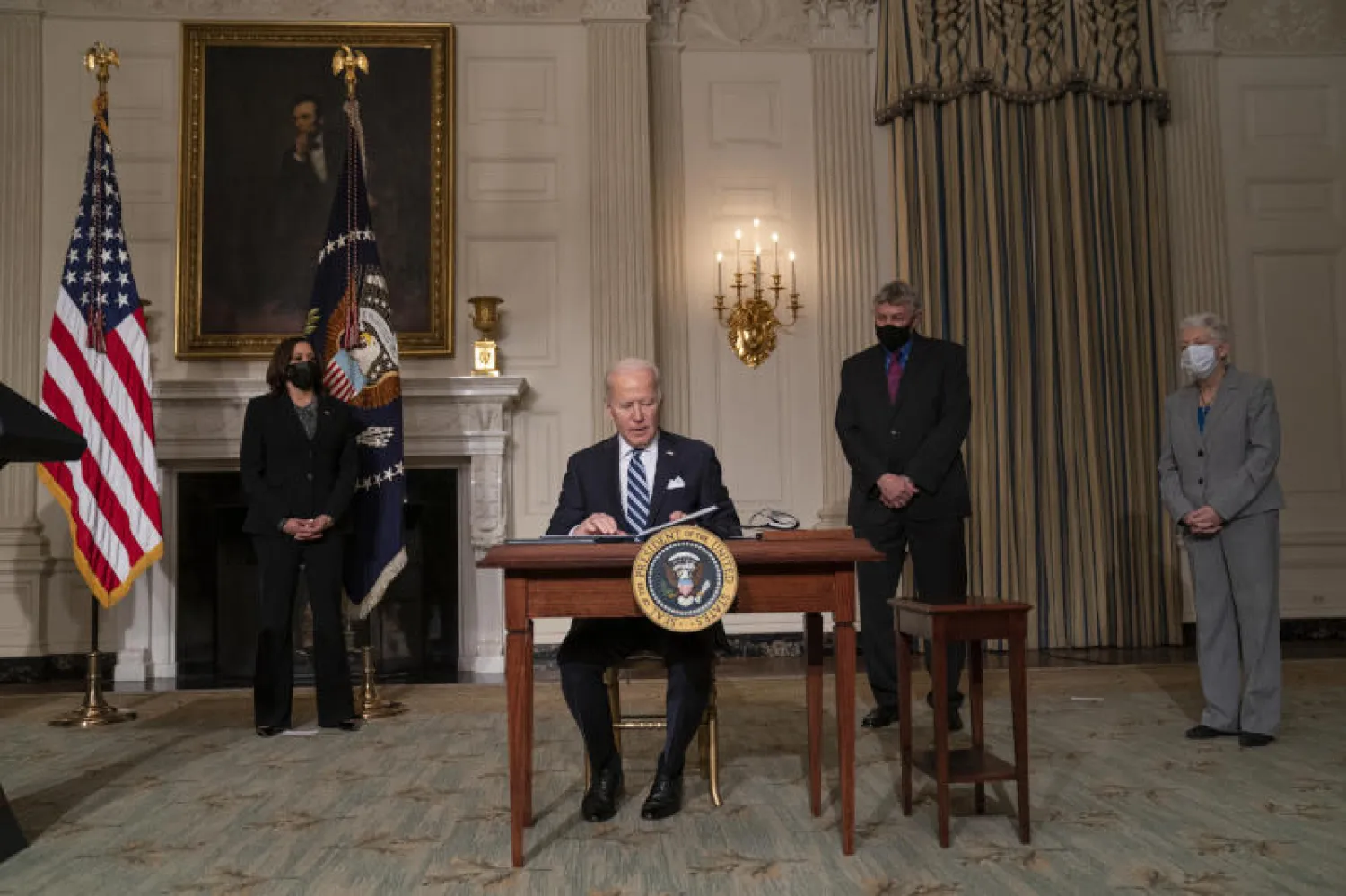 الرئيس الأميركي جو بايدن يوقع أوامر تنفيذية في البيت الأبيض (أ.ف.ب)