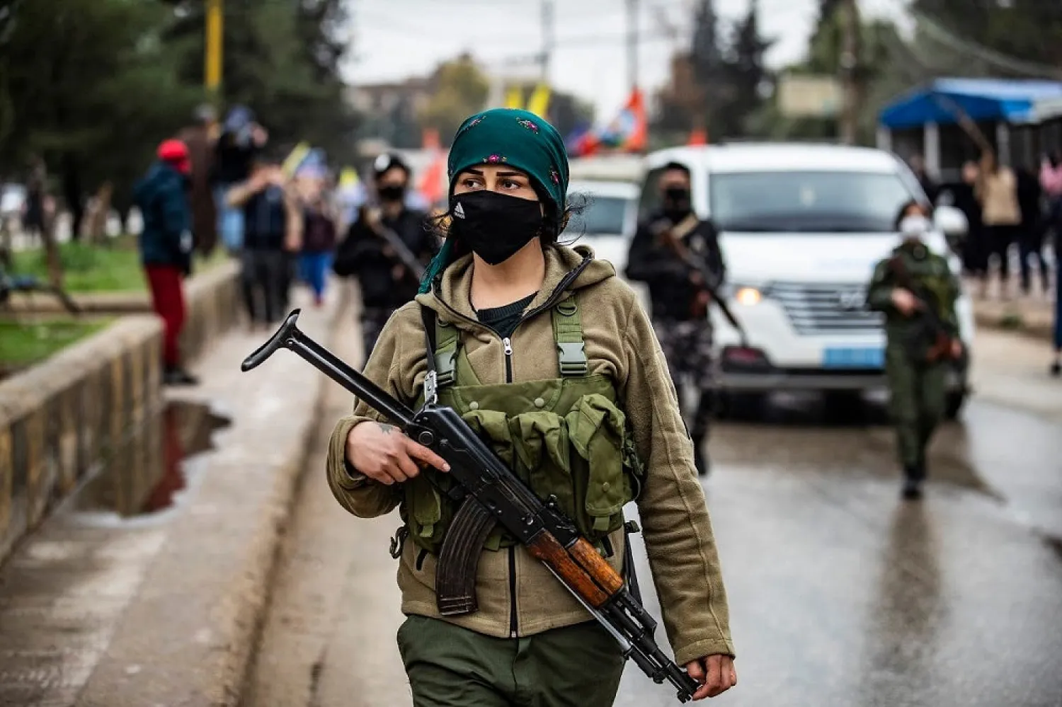 A member of the Kurdish internal security services known as Asayish stands guard as Syrian Kurds demonstrate in the northeastern city of Qamishli on January 20, 2021. (AFP)
