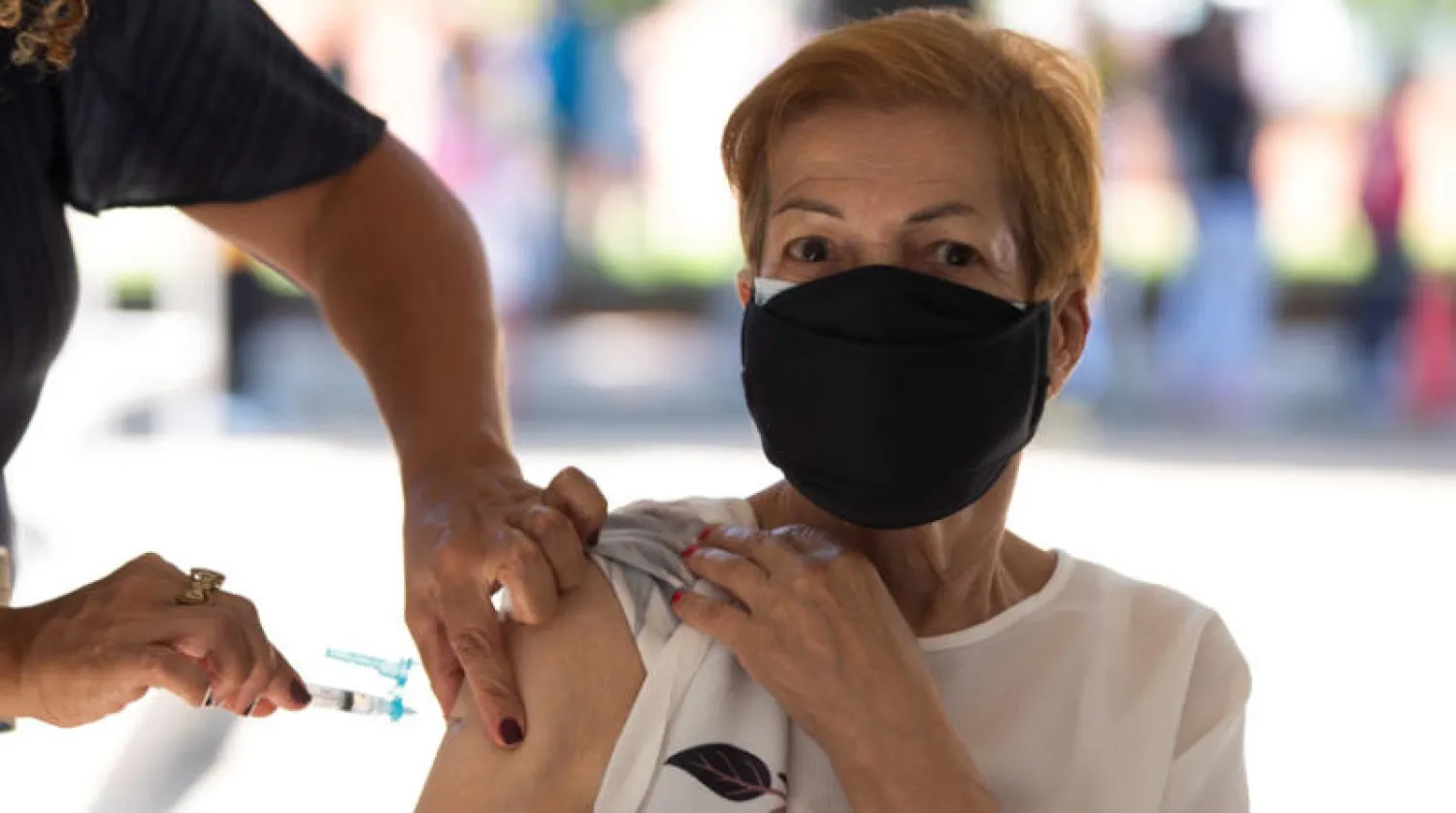 برازيلية تتلقى اللقاح في برازيليا أمس (إ.ب.أ)