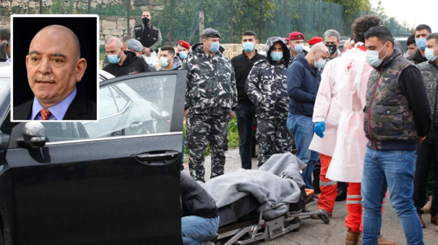 عناصر أمنية بجوار جثمان لقمان سليم قرب سيارته في قرية العدوسية جنوب لبنان... وفي الإطار الناشط الراحل (أ.ب/ أ.ف.ب)