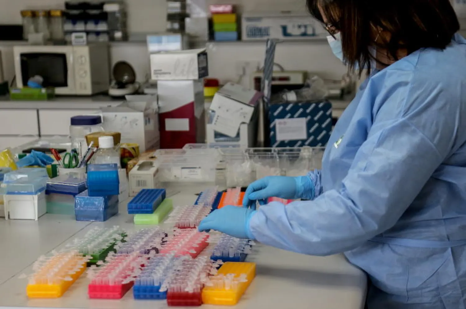 عاملة في مختبر مستشفى رفيق الحريري في بيروت تحلل اختبارات لكشف «كوفيد-19» (إ.ب.أ)