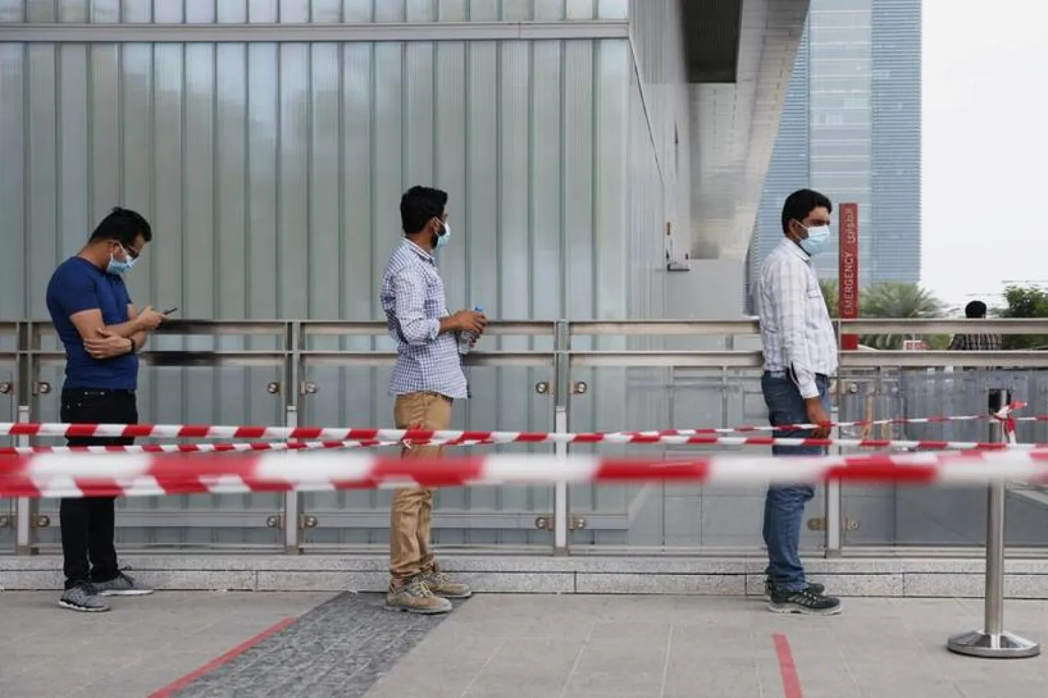 FILE PHOTO: People wearing protective face masks wait to be tested, amid the coronavirus disease (COVID-19) outbreak, at the Cleveland Clinic hospital in Abu Dhabi, United Arab Emirates, April 20, 2020. REUTERS/Christopher Pike
