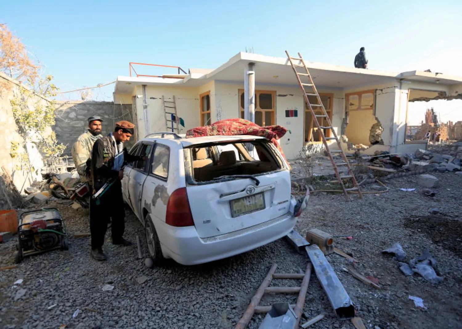 رجال شرطة يتفقدون موقع انفجار سيارة مفخخة بنقطة تفتيش في منطقة خوجياني بإقليم ننكرهار (رويترز)