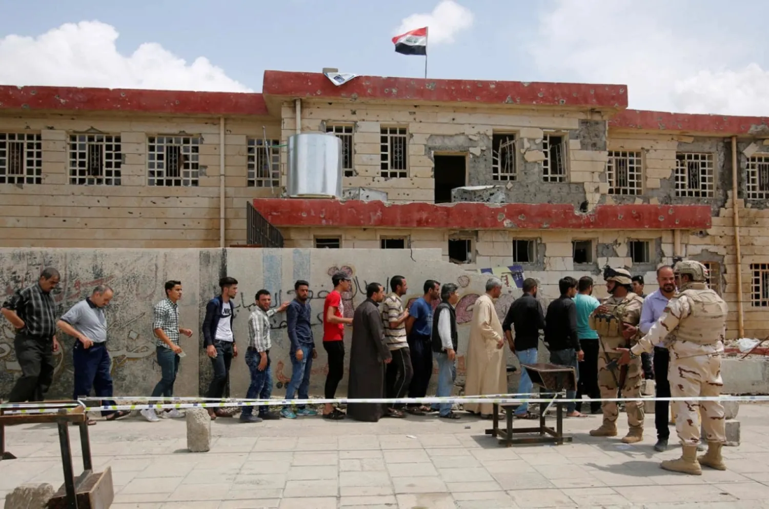 Iraqis stand in a queue to cast their vote at a polling station during the parliamentary election in Mosul, Iraq in 2018. (Reuters)