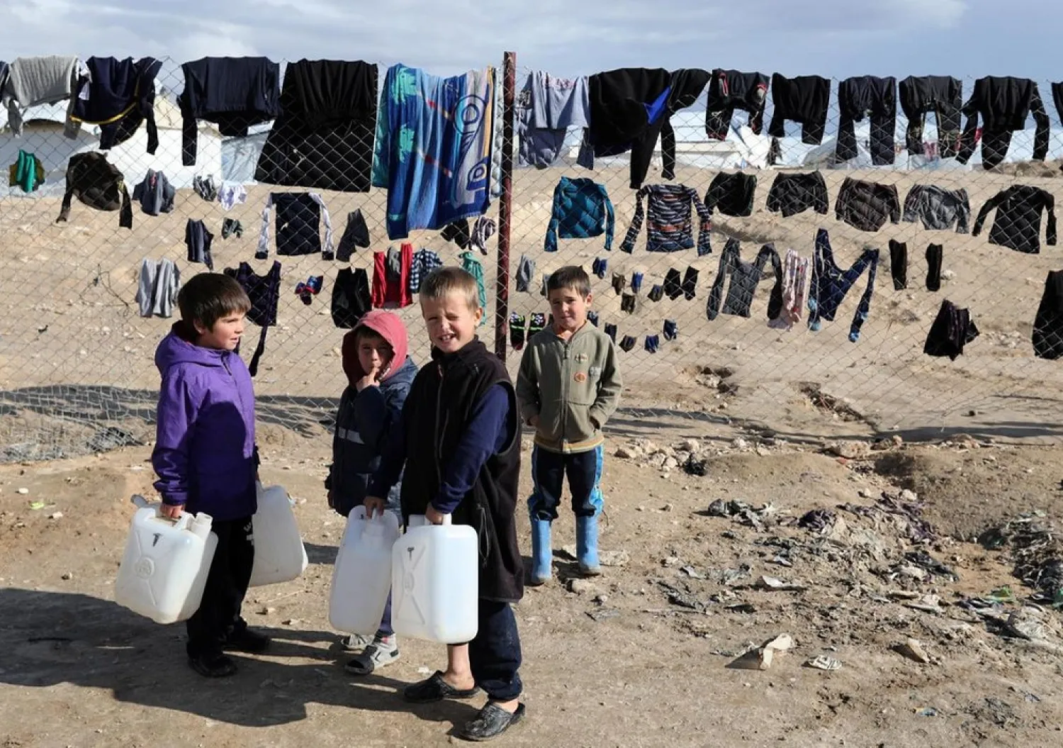 Children hold onto water containers in al-Hol camp, Syria. (Reuters)