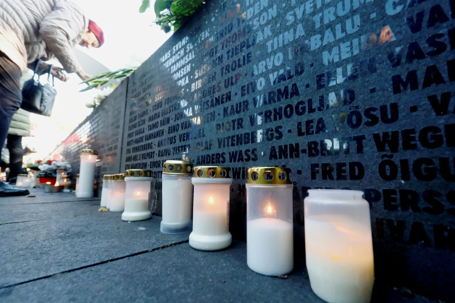 FILE PHOTO: Candles are seen next to the names of victims during a ceremony to mark the 25th anniversary of a maritime disaster when MS Estonia, carrying 803 passengers and 186 crew, sank in the Baltic Sea, in Tallinn, Estonia September 28, 2019. REUTERS/Ints Kalnins/File Photo