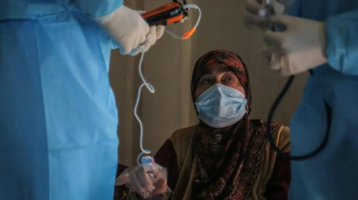 Kovid-19 hastasını evinde ziyaret eden bir sağlık ekibi (DPA)