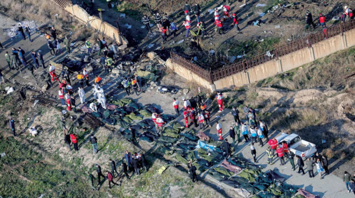 فرق الإسعاف تجمع أشلاء ضحايا الطائرة الأوكرانية بعد ساعات من إصابتها بصاروخين جنوب طهران في 8 يناير 2020 (إ.ب.أ)