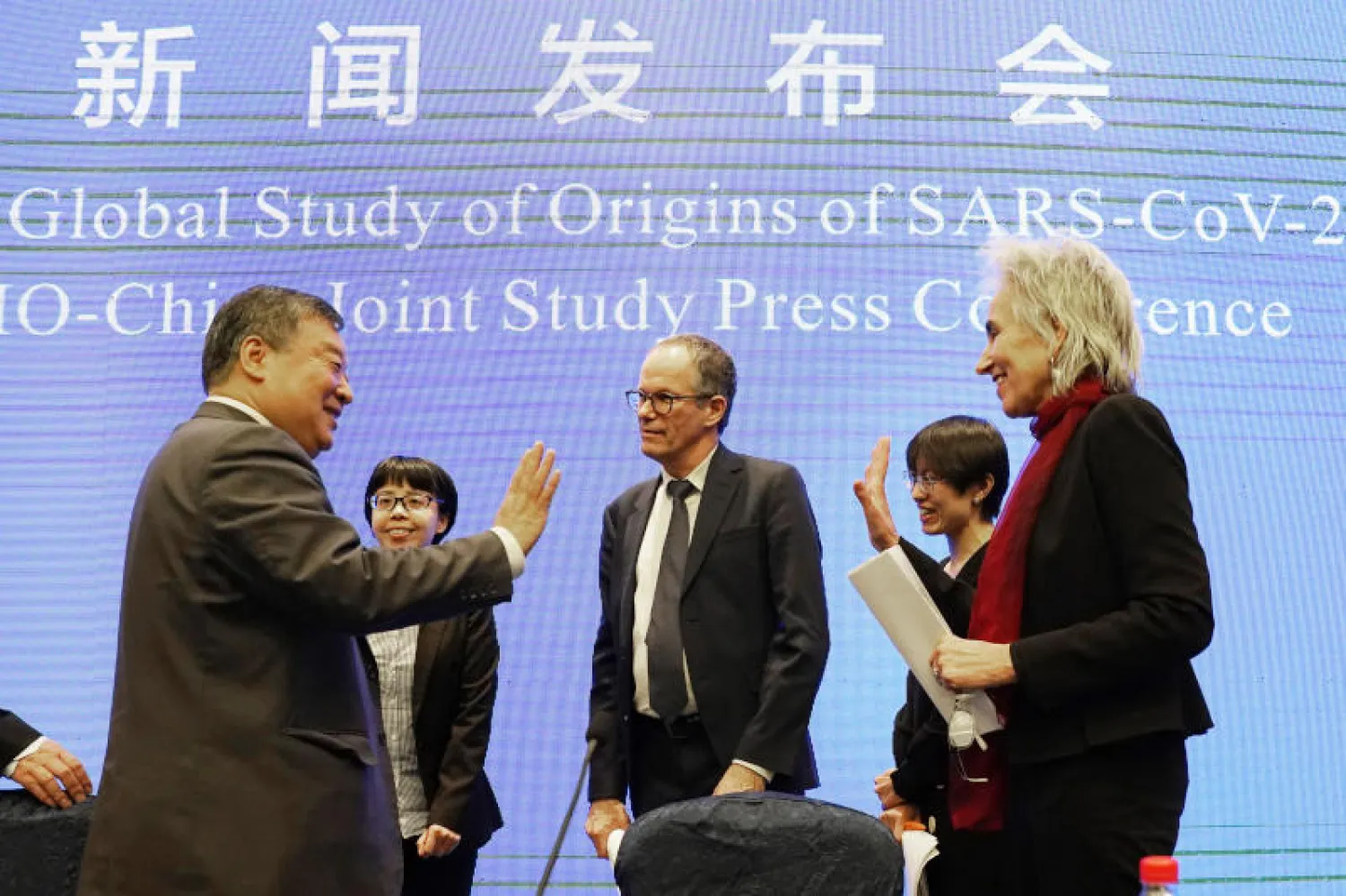 أعضاء فريق منظمة الصحة العالمية في ووهان في ختام المؤتمر الصحافي أمس لإعلان نتائج التحقيق في نشأة فيروس كورونا (أ.ب)