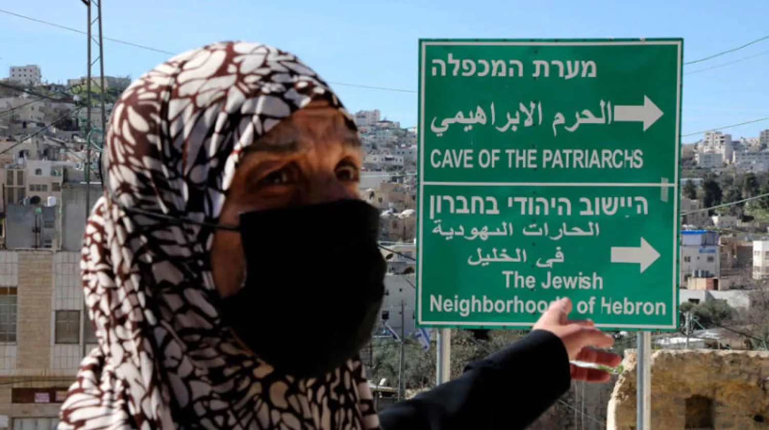 لافتة رفعت حديثاً توضح اتجاهين أحدهما للمستوطنات اليهودية في الخليل والآخر للحرم الإبراهيمي (أ.ف.ب)