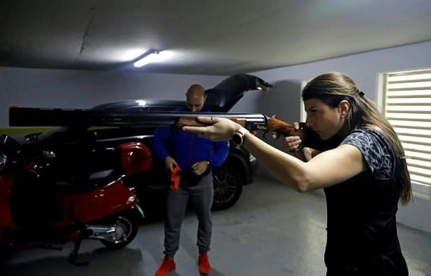With Lebanon's shooting clubs closed by a strict lockdown, Olympic trap shooter Ray Bassil trains with a virtual shotgun on a makeshift range in the car park of her apartment block - AFP
