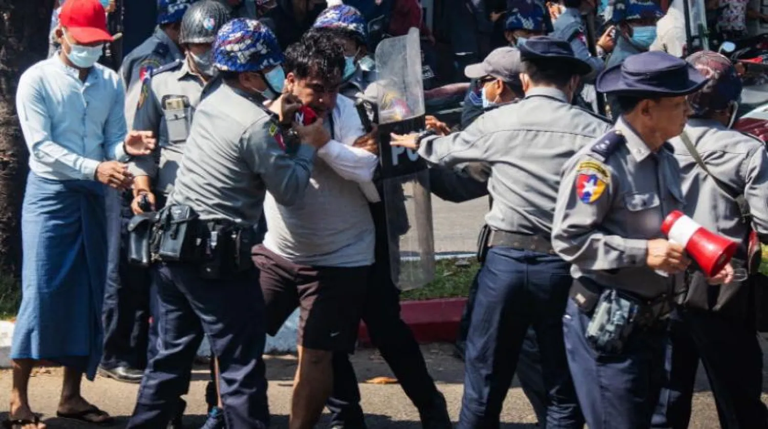 Polis memurları, Myanmar'ın güneybatısındaki Maulamiyin şehrinde bir protestocuyu tutukladı (EPA) 
