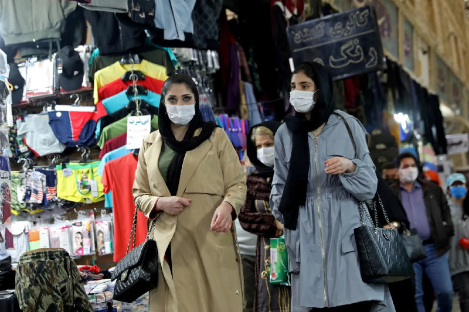 أشخاص يضعون الكمامات في طهران (رويترز)