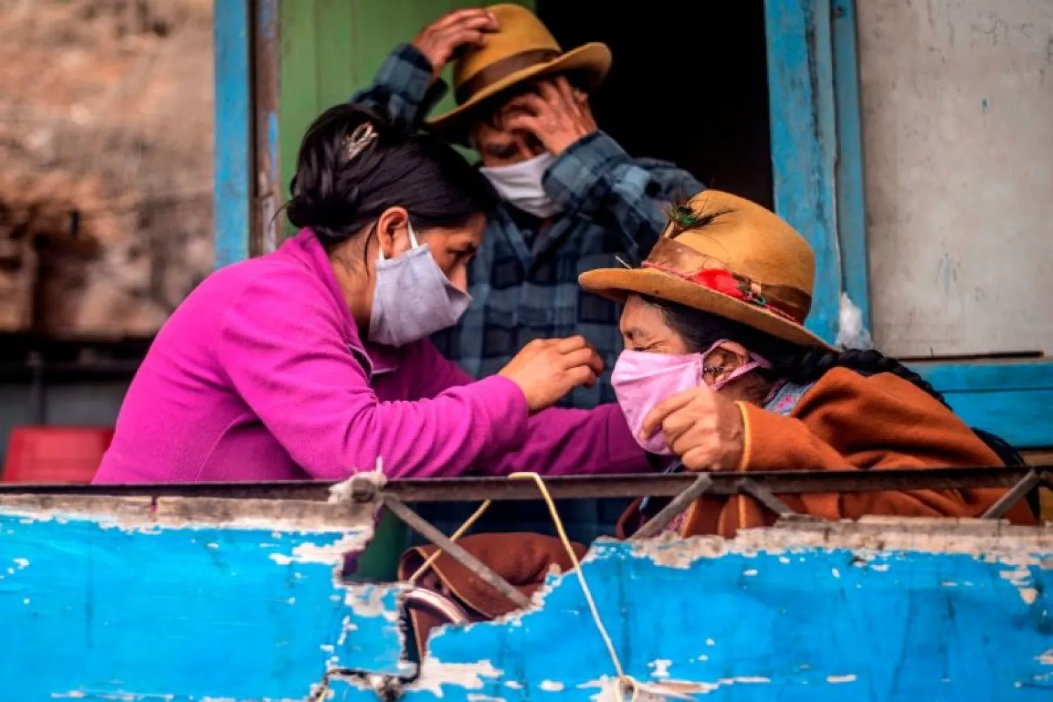 A woman adjusts her mother's face mask at their house on the southern outskirts of Lima, Peru, May 28, 2020. AFP