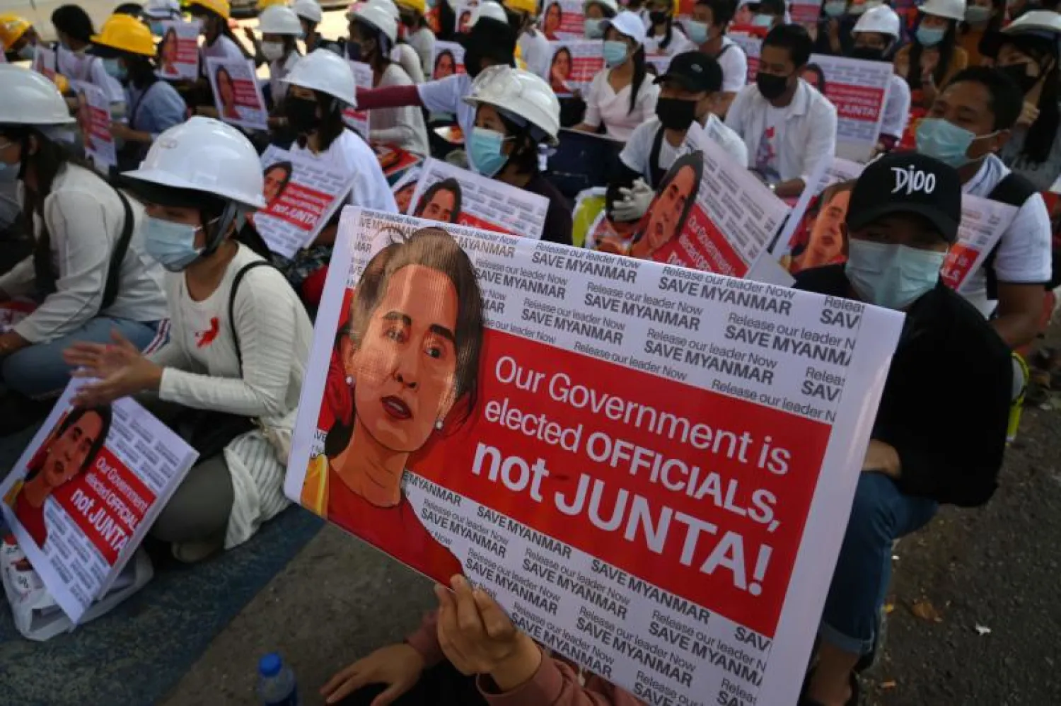 متظاهرون ضد الانقلاب في ميانمار يرفعون صور رئيسة الوزراء الفعلية أونغ سان سو تشي (أ.ف.ب)