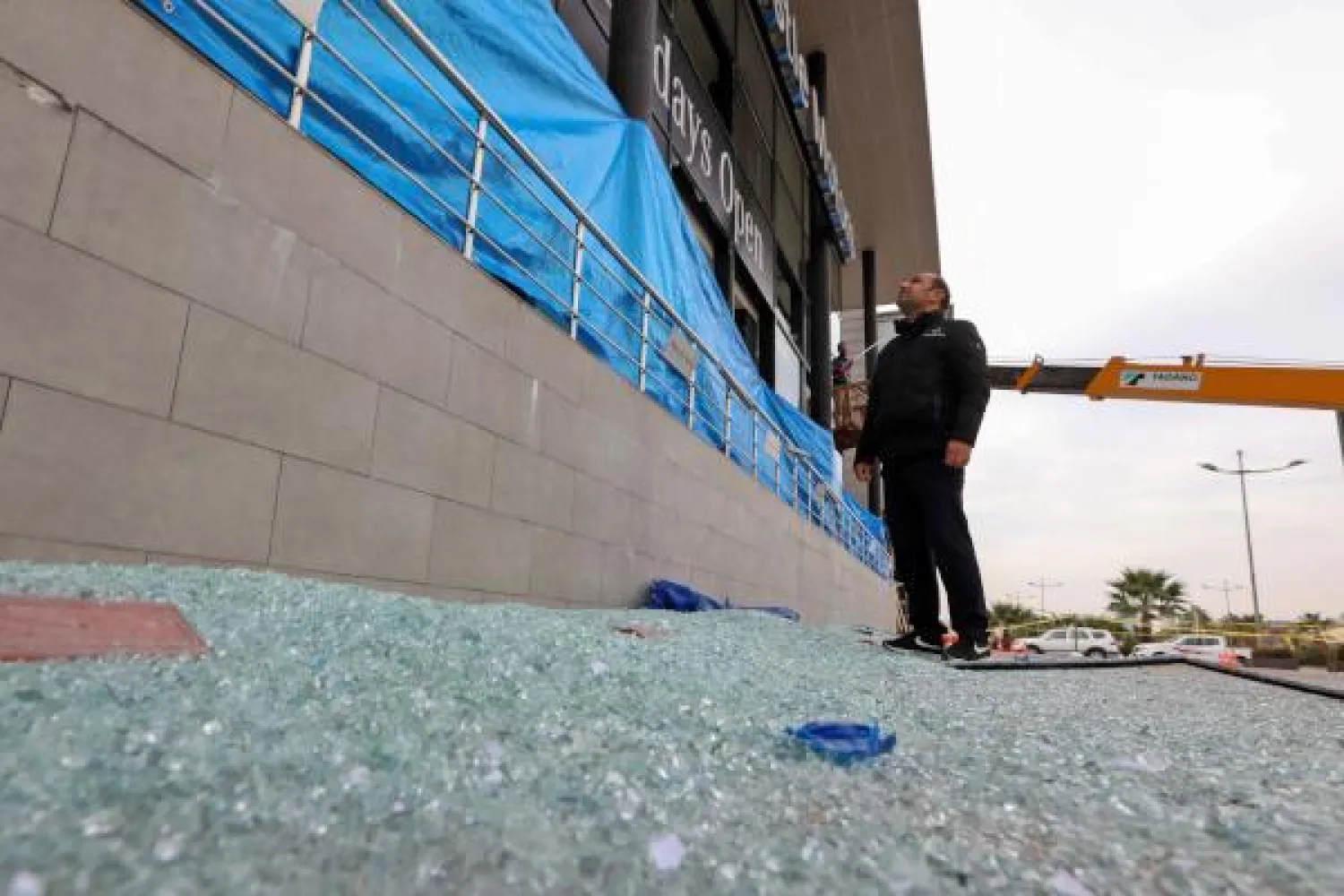 رجل يتفقد الأضرار التي خلفها الهجوم الصاروخي على مطار أربيل (ا.ف.ب)