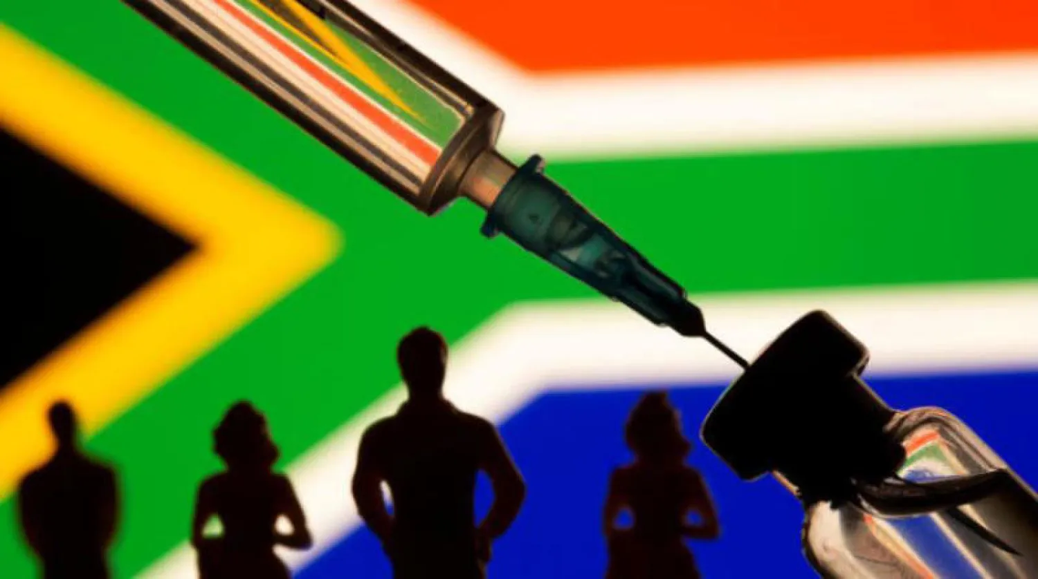 صورة توضيحية لحقن وقنينة لقاح وخلفهما علم دولة جنوب أفريقيا (رويترز)