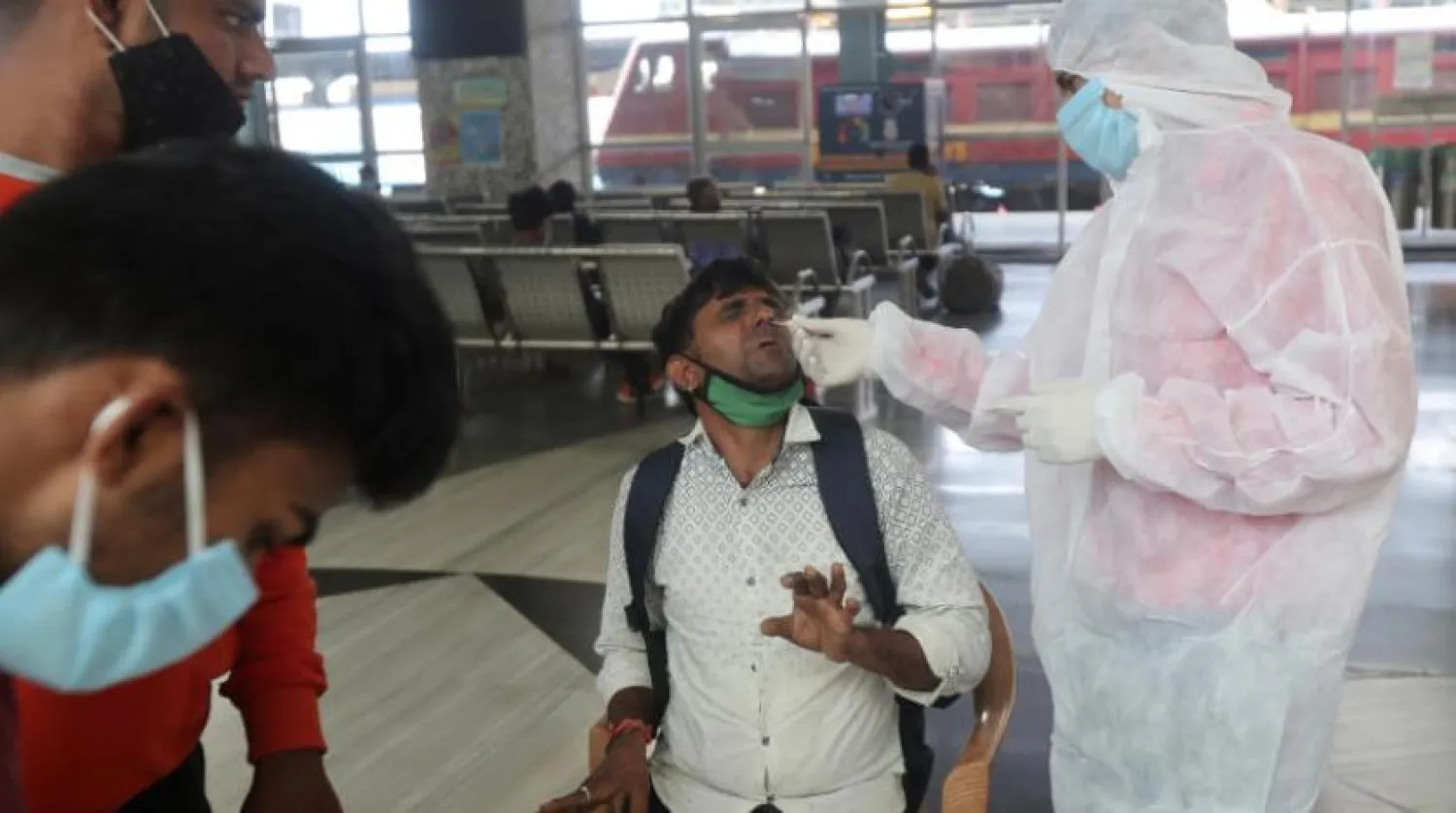 Mumbai’deki Bandra tren istasyonunda koronavirüs testi yapan bir sağlık görevlisi (AP)