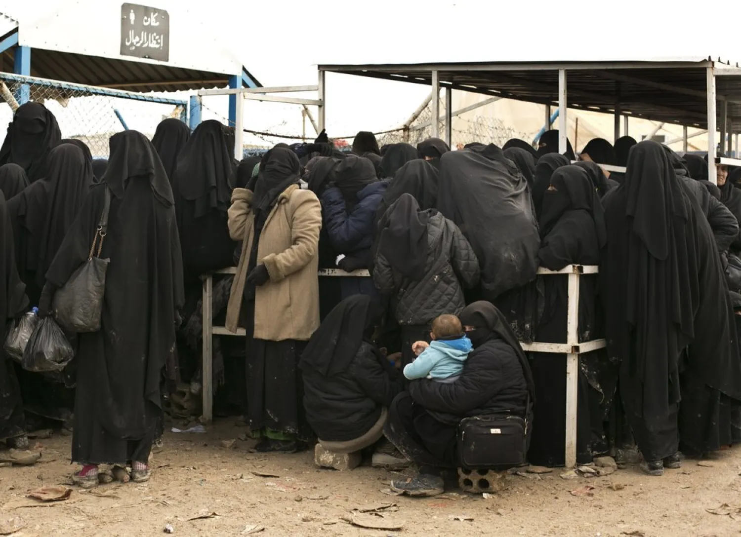 FILE - In this March 31, 2019 file, photo, women residents from former ISIS-held areas in Syria line up for aid supplies at Al-Hol camp in Hassakeh province, Syria. (AP Photo/Maya Alleruzzo, File)

