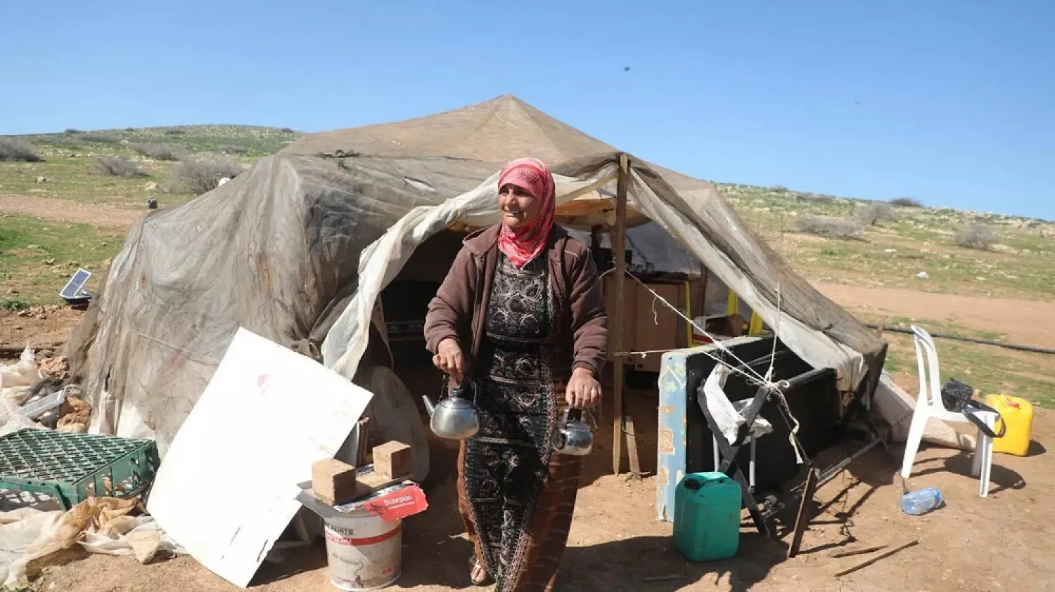 Fadwa Abdelghani walks outside her tent in the Bedouin village of Humsah al-Baqia, which has emerged as a flashpoint in the struggle over the Israeli-occupied West Bank. (AFP)