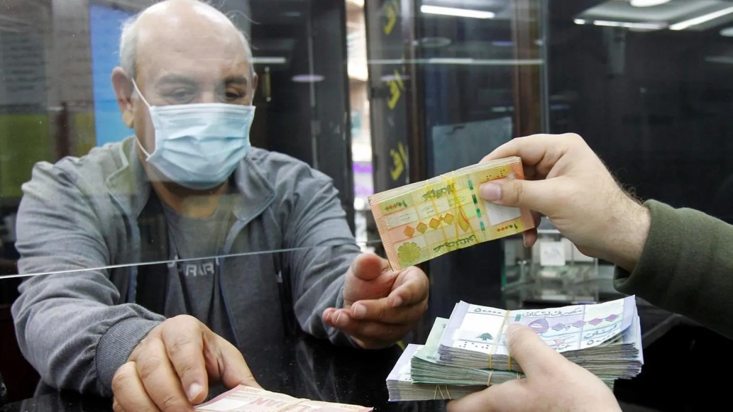 Lebanese pound notes change hands at a currency exchange in Beirut. (Reuters)