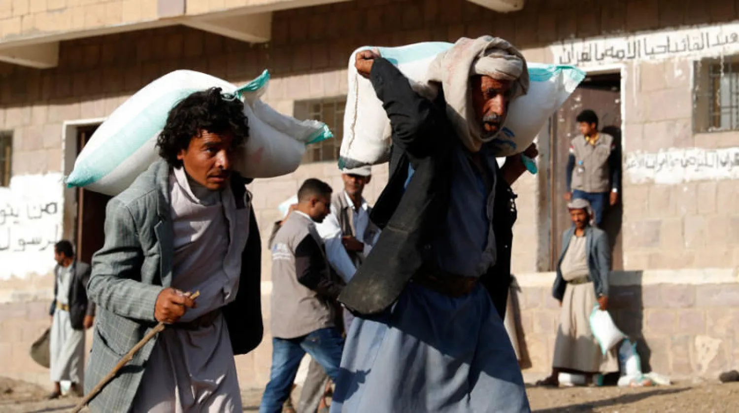 يمنيان يحصلان على مساعدات غذائية من جمعية خيرية في صنعاء (إ.ب.أ)