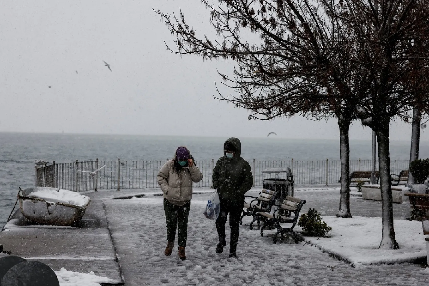 People wearing protective masks walk by the Bosporus, in Istanbul, Turkey, Feb. 14, 2021. (Reuters)