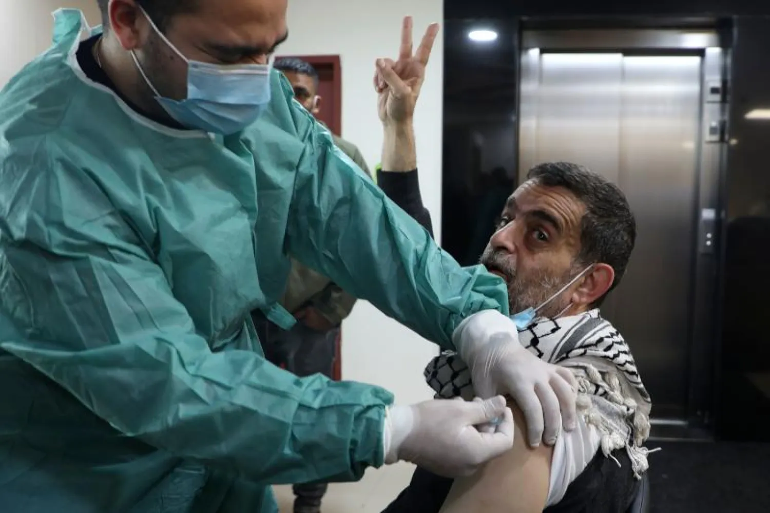 عامل بمجال الصحة يتلقى لقاحاً ضد «كوفيد-19» في مستشفى بمدينة نابلس في الضفة الغربية (أ.ف.ب)