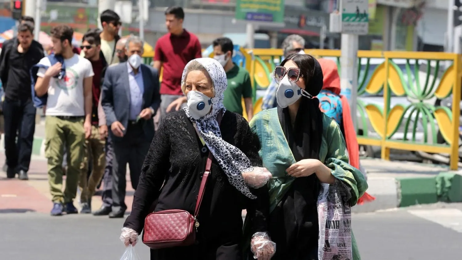 Iranian women wearing protective masks cross a street in Tehran. (AFP file photo)