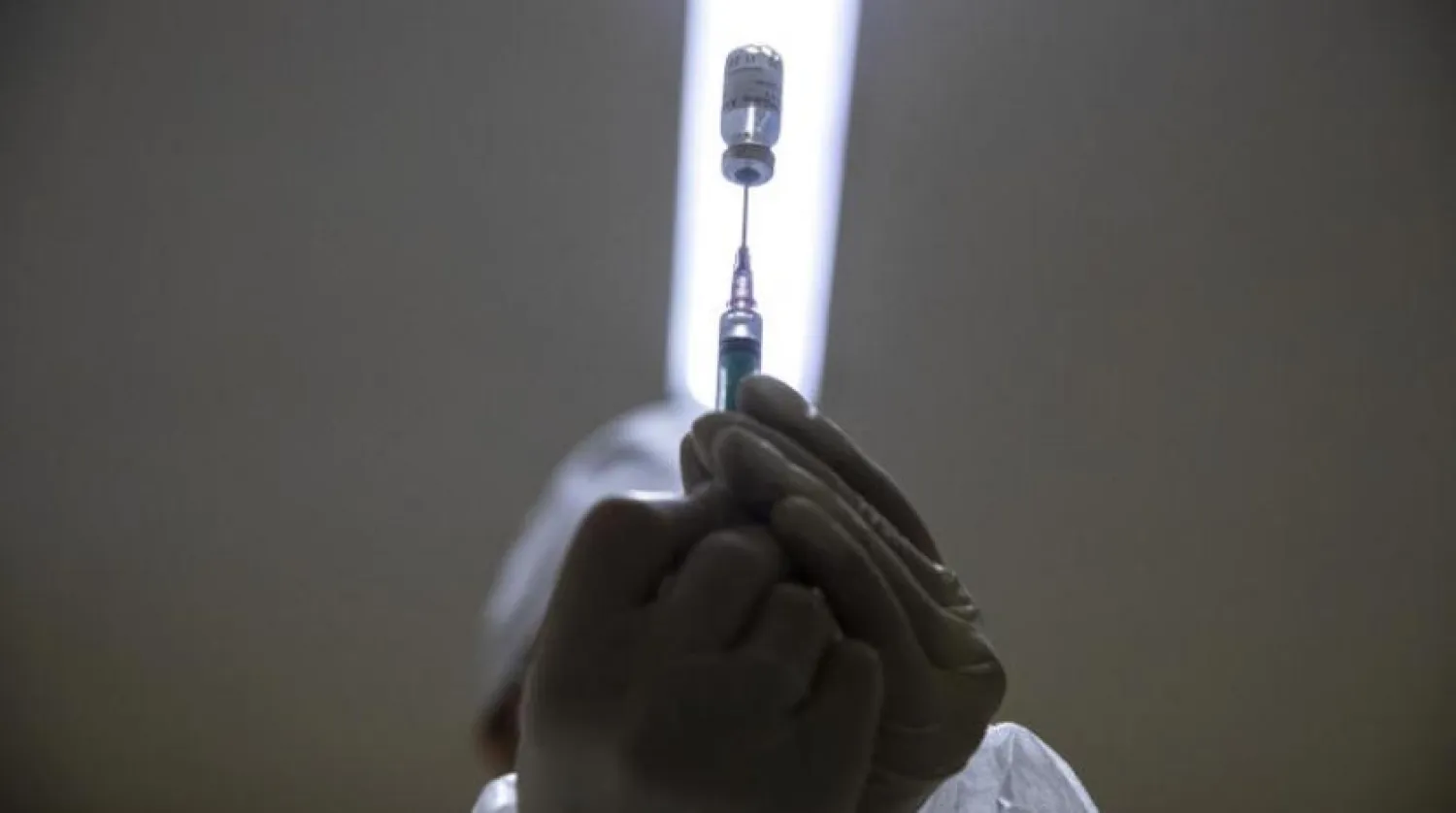 Bir sağlık çalışanı Moskova'da bir doz koronavirüs aşısı hazırlıyor (AP)